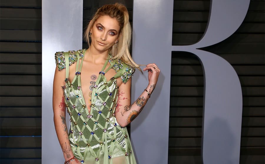 Paris Jackson holding her hair while posing on the red carpet in 2018