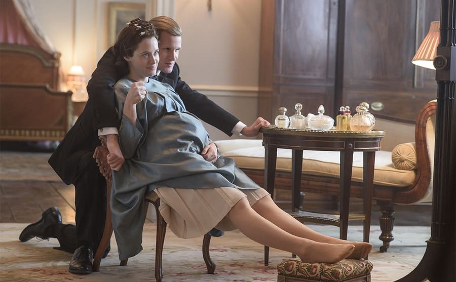 Matt Smith as Prince Phillip behind a pregnant Claire Foy as the Queen in a scene from The Crown 