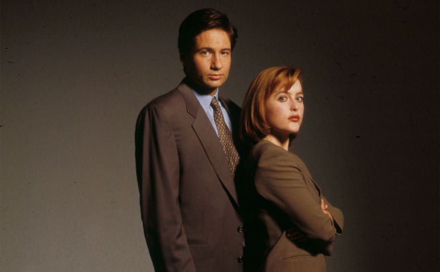 David Duchovny and Gillian Anderson wearing suits standing one next to each other