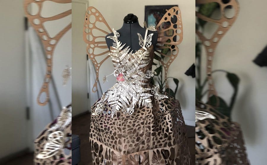 A spaghetti strap dress made out of cardboard and brown paper bags with leaf and butterfly accents 