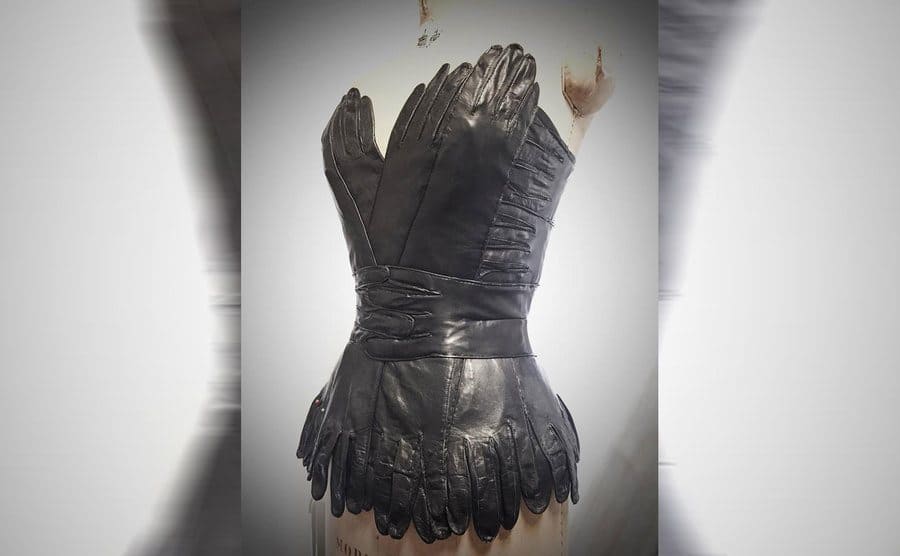 A strapless corset made out of black leather gloves 