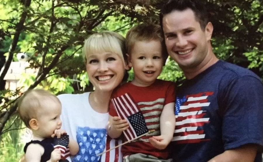Sherri and Keith Papini with their two children holding little USA flags