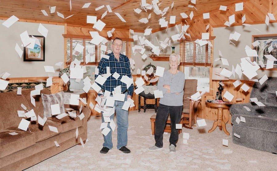 Money flying through the air around Jerry and Marge Selbee in their home