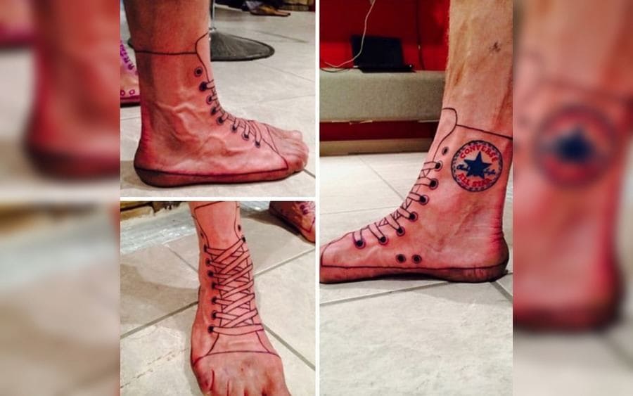A tattoo of a Converse shoe on his feet