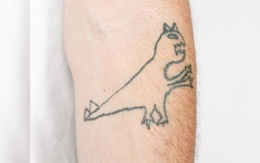 A tattoo of a dinosaur on a guy's arm