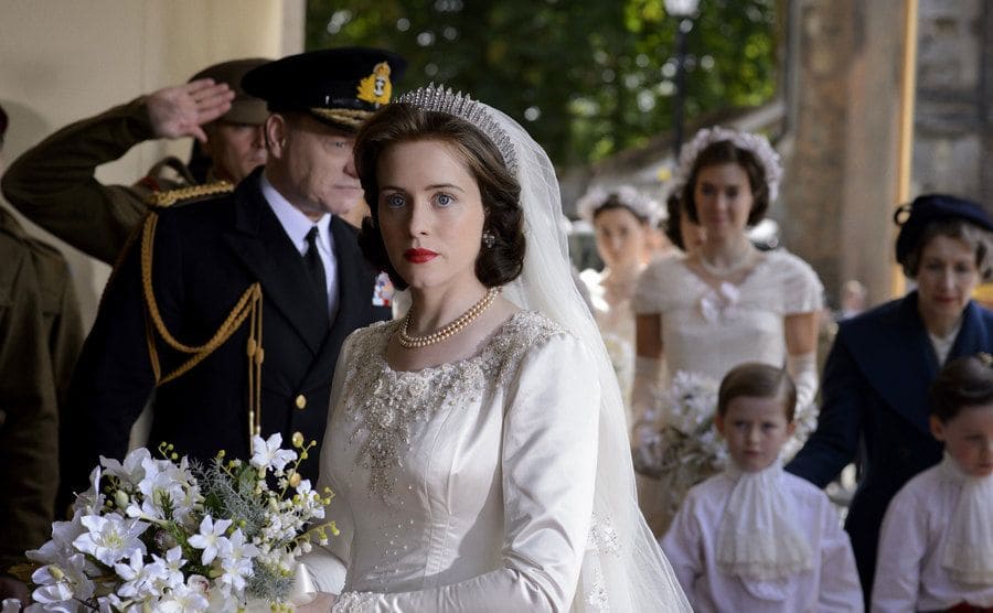 Claire Foy in a wedding dress walking towards the hall 