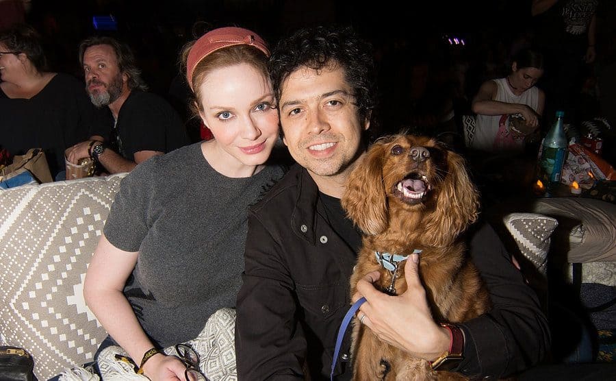 Christina Hendricks and Geoffrey Arend with their dog cozied up under a blanket 