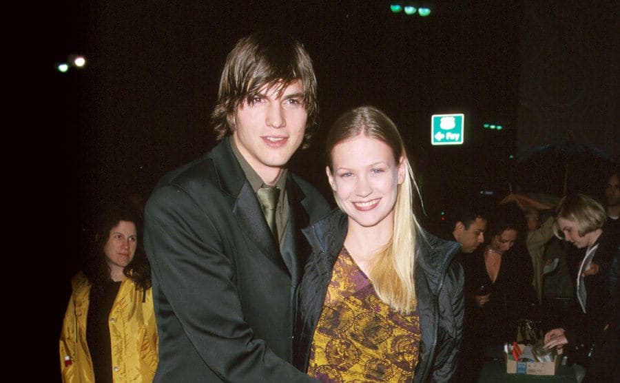 Ashton Kutcher hugging January Jones for a pose on the red carpet 