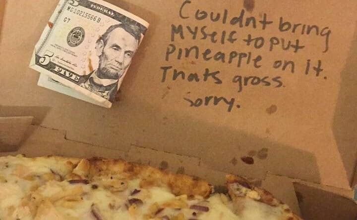 An open pizza box with a note written on top apologizing for not adding the pineapple topping and a 5 dollar bill stuck on next to it. 