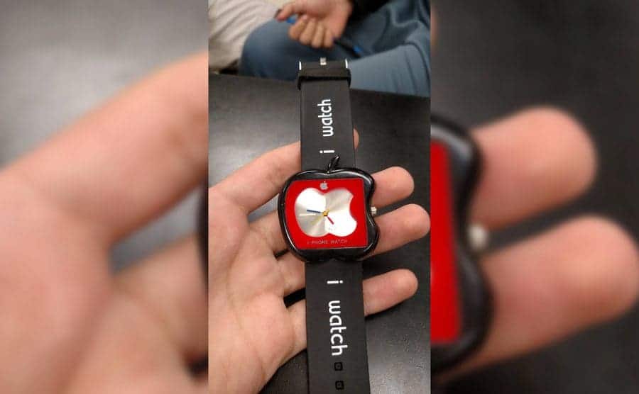 a black plastic wristwatch shaped like an apple that is in no way an apple watch. 