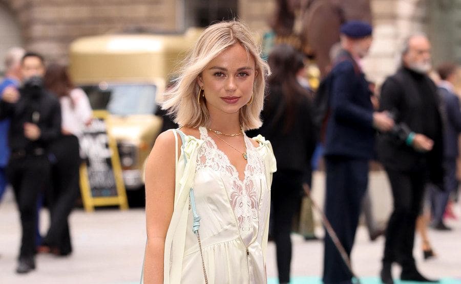 Lady Amelia Windsor at an art exhibition party wearing all white with a light blue purse 