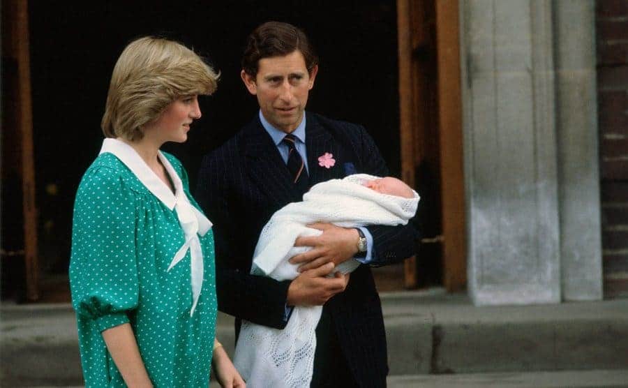 Princess Diana and Prince Charles holding Prince William outside of the hospital after his birth 