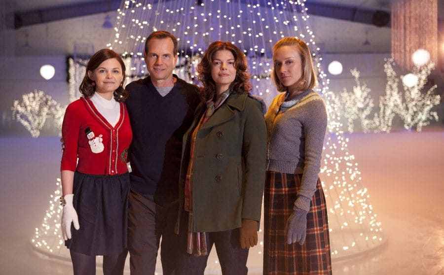 Bill Paxton with Jeanne Tripplehorn, Chrloe Sevigny, and Ginnifer Goodwin standing in front of a room filled with Christmas lights 