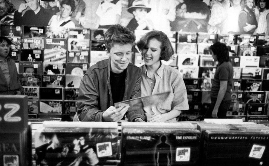 Anthony Michael Hall and Molly Ringwald looking at records together 