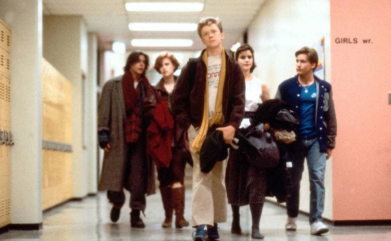 The five kids in The Breakfast Club walking down the hallway behind Anthony Michael Hall 