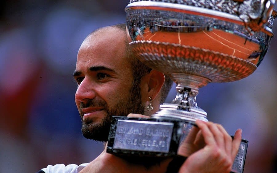 Andre Agassi of the USA holds up the trophy after defeating Andrei Medvedev of Ukraine to win the men's singles final of the French Open at Roland Garros in Paris, France.