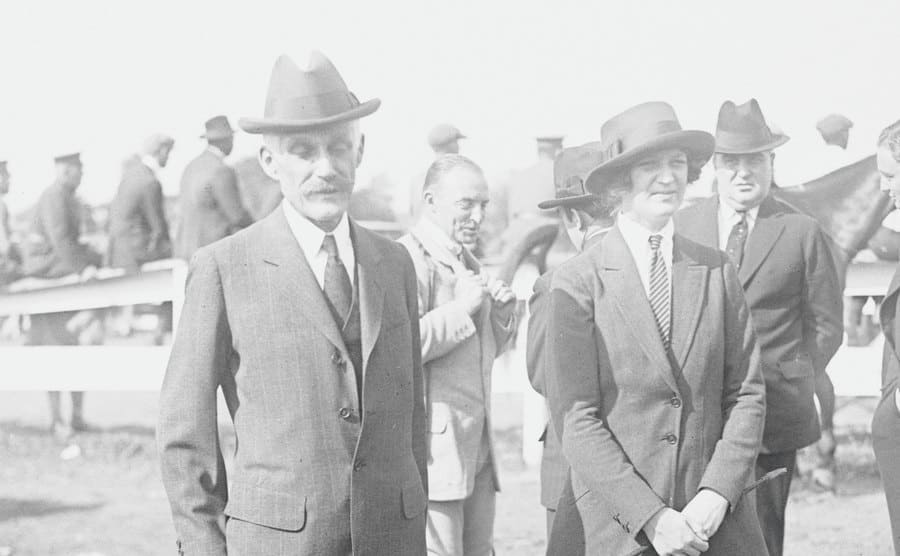 Andrew and his daughter Ailsa standing outdoors at an event in the early 1900s 