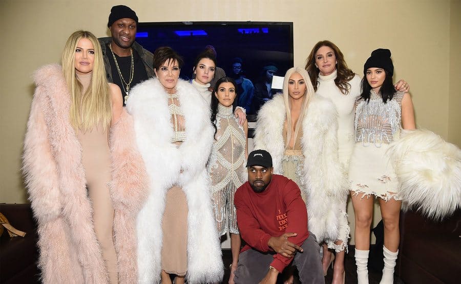 The Kardashian family posing with Lamar Odom and Kanye West backstage at a fashion show 