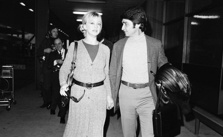 Goldie Hawn and Gus Trikonis walking through Heathrow Airport
