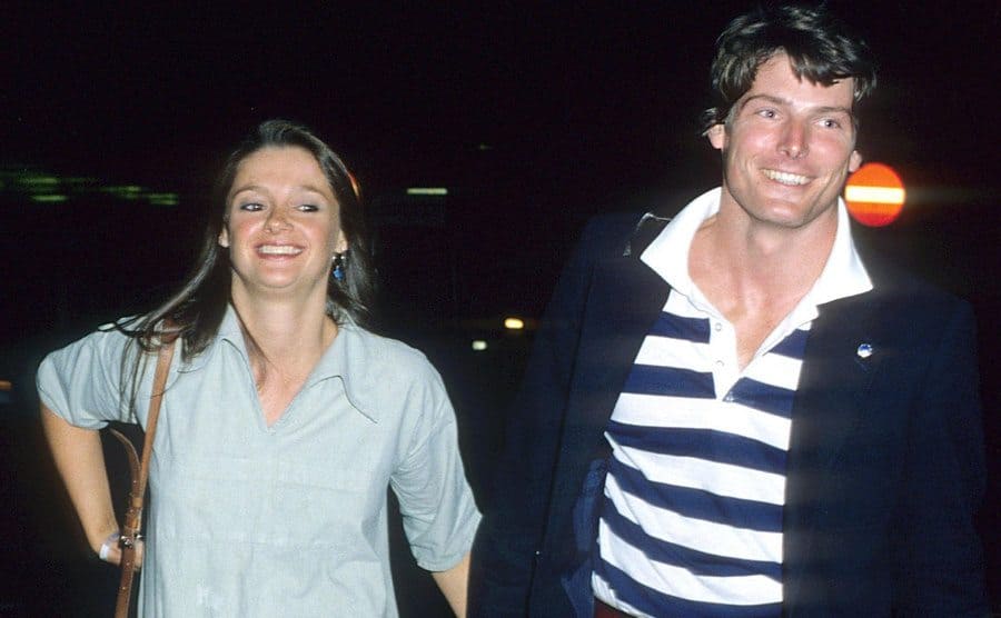 Gae Exton and Christopher Reeve holding hands walking outside of the airport 