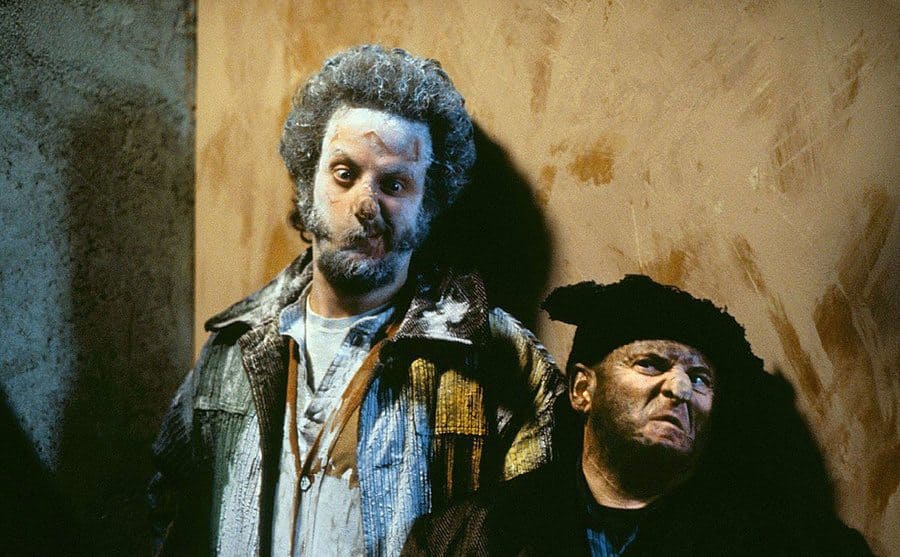Daniel Stern with white powder all over his face and chest with Joe Pesci standing next to him covered in soot 