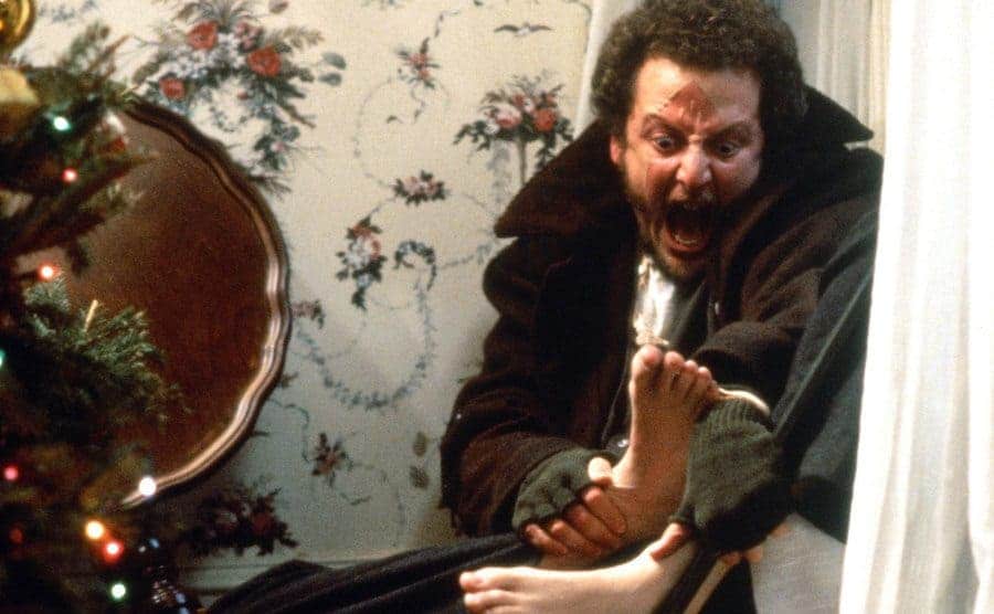 Daniel Stern holding his foot in pain in a scene from Home Alone 