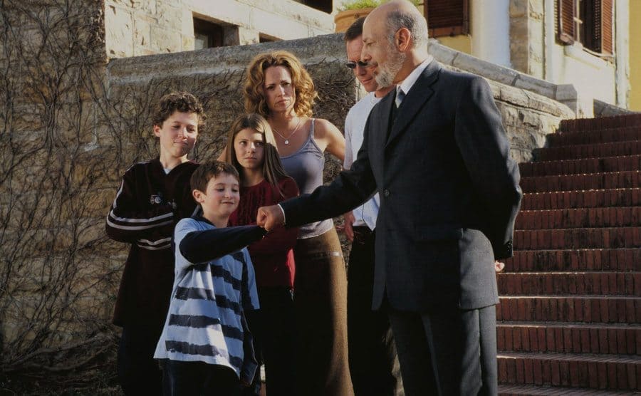 Mike Weinberg as Kevin McCallister with his family surrounding him while he fist bumps Erick Avari 