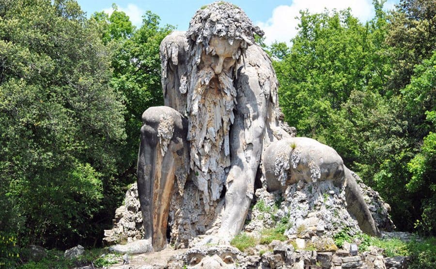 Colosso dell’Appennino, a sculpture of a man leaning down with his hair and beard a mess all around his face 