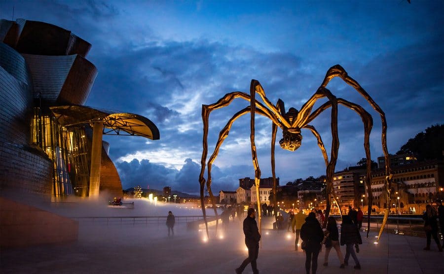 The large spider sculpture outside of the museum at dusk 