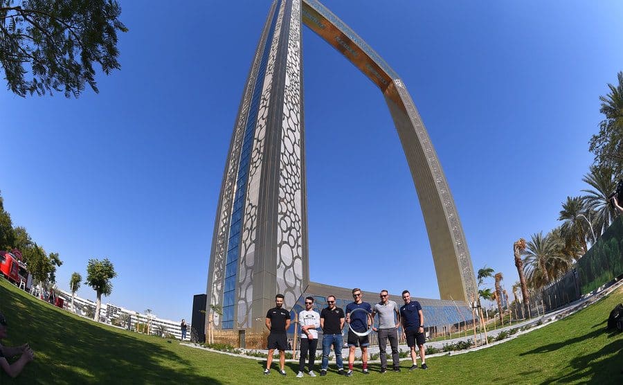 The large frame with six tourists standing in front of it 