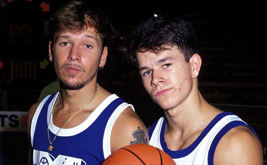 Mark Wahlberg with Donnie in basketball uniforms posing on the court 