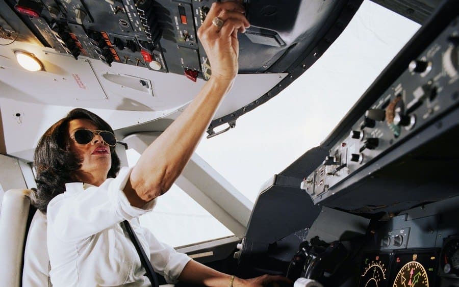 Female airplane pilot, operating controls, low angle view