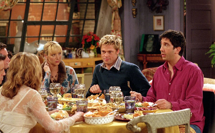 The cast of Friends sitting around the dinner table eating 