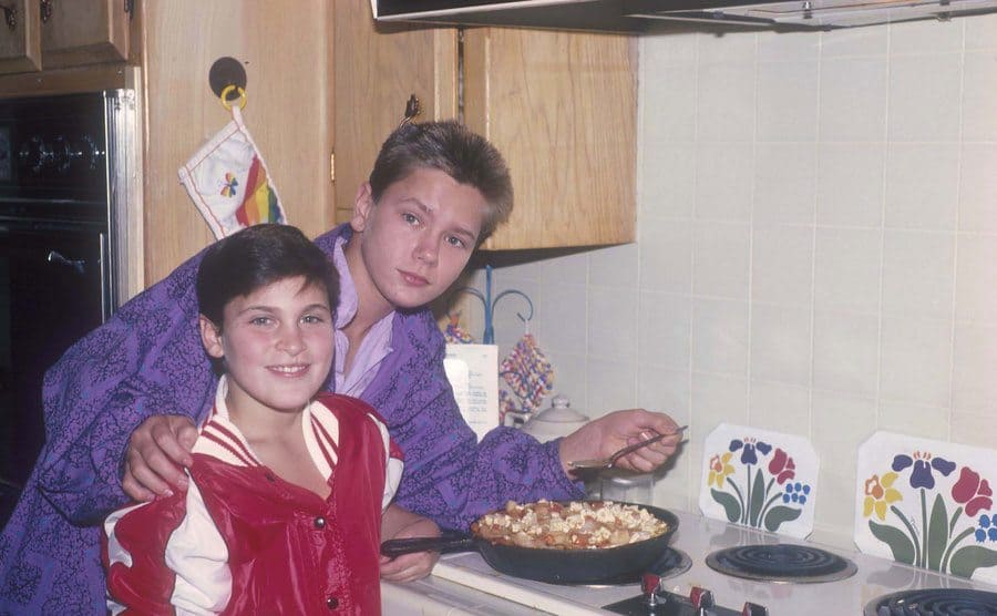 Joaquin and River Phoenix eating out of a pan on the stovetop 