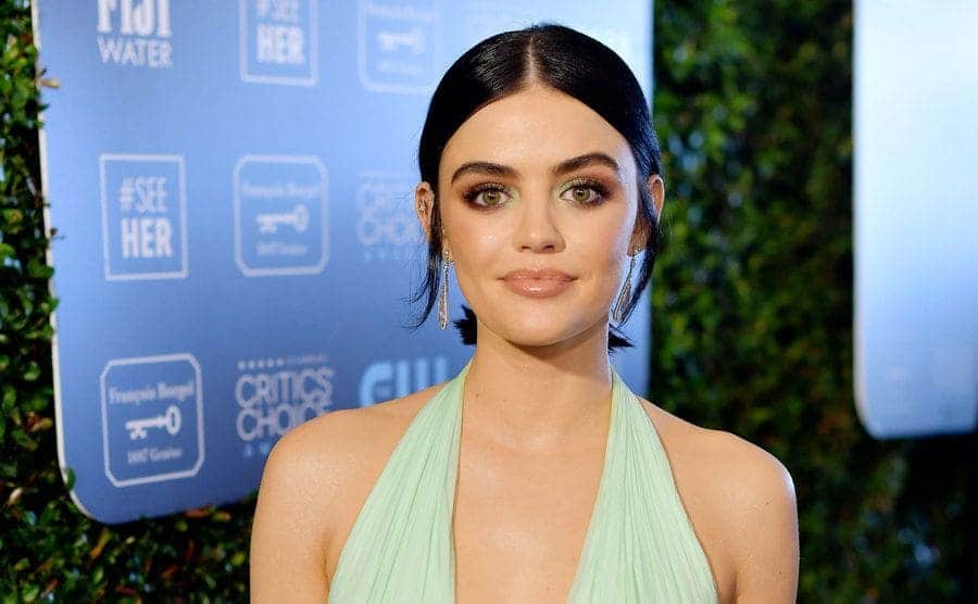 Lucy Hale on the red carpet in a v-neck light green dress