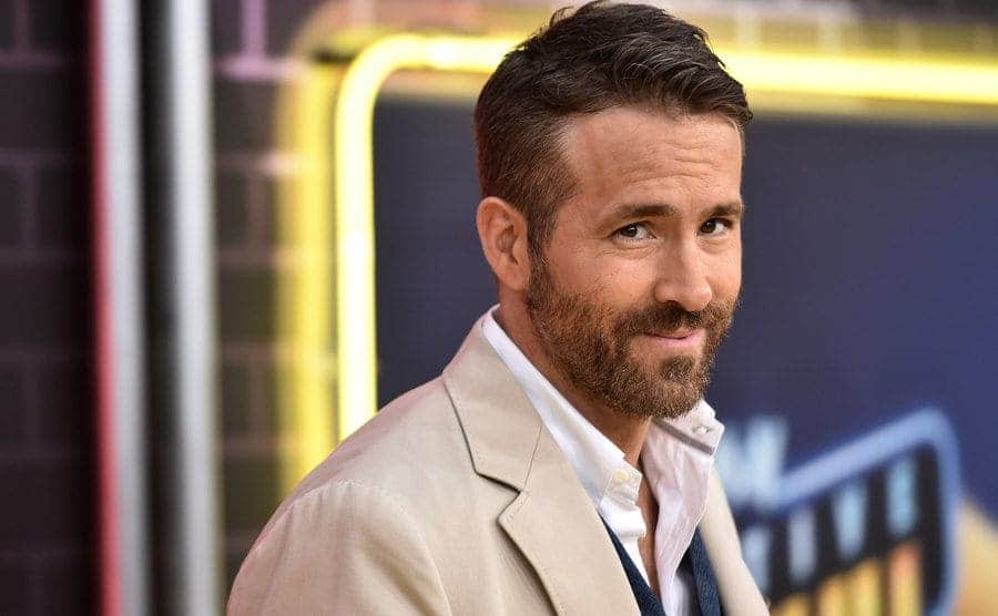 Ryan Reynolds looking into the camera while posing at an event 