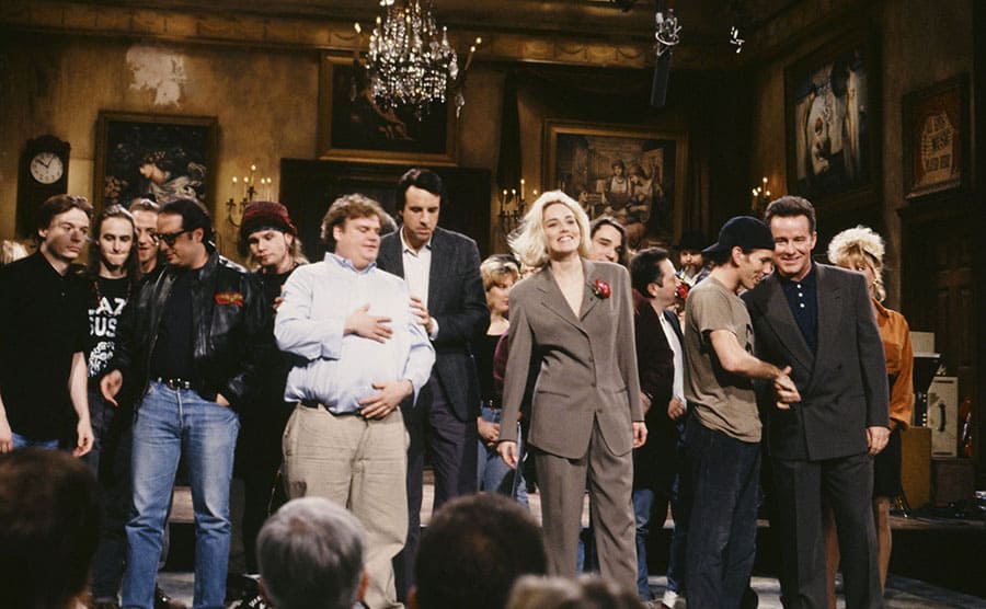 Chris Farley and other cast members on the stage of SNL at the end of an episode during the closing credits 