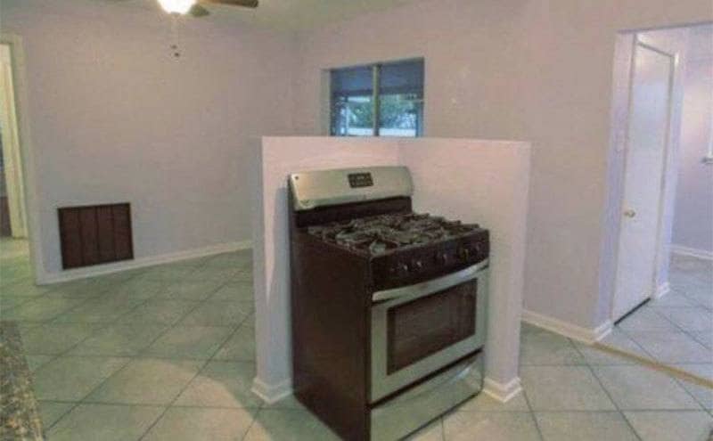 A lonely single oven sits behind a short wall in an empty kitchen.