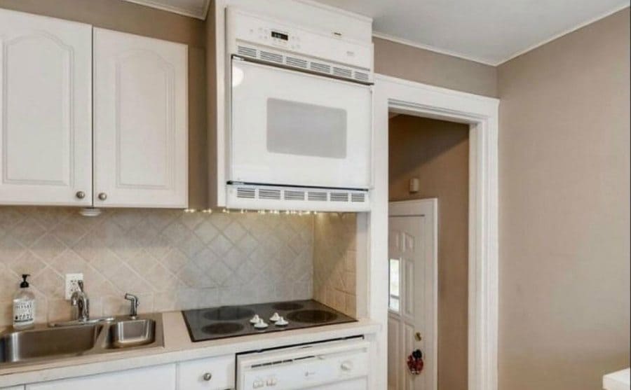 An oven placed above the stove as a kitchen hood. 