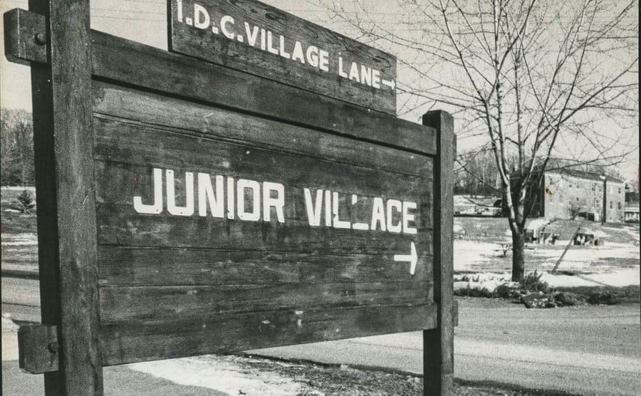 A big wooden sign that is indicating the direction for Junior Village.