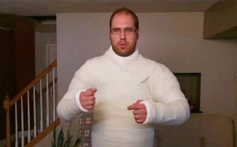 Kevin is standing in his living room in an entire upper body cast, torso, and arms. 