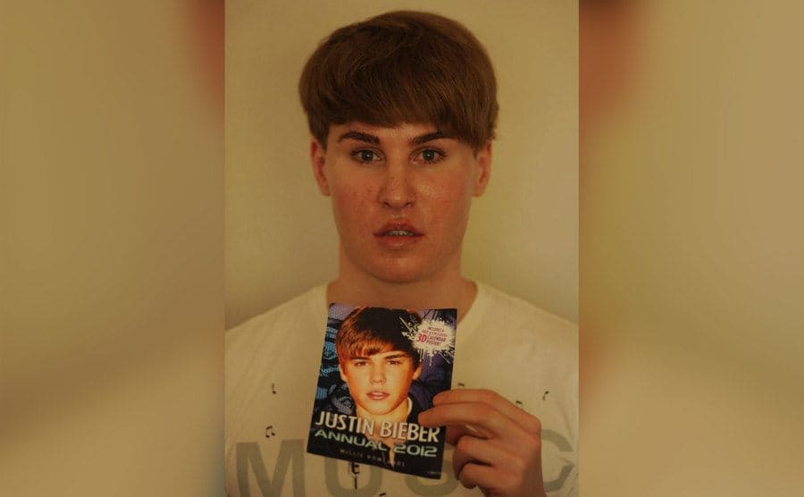 Toby Sheldon holding up a photo of Justin Beiber beneath his face; the similarity is shocking. 