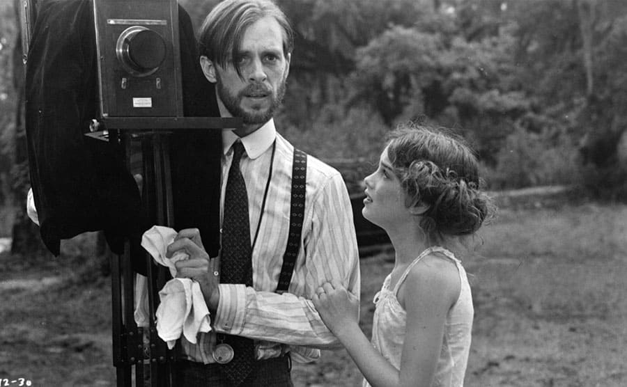 Brooke Shields and Keith Carradine standing next to an old camera 