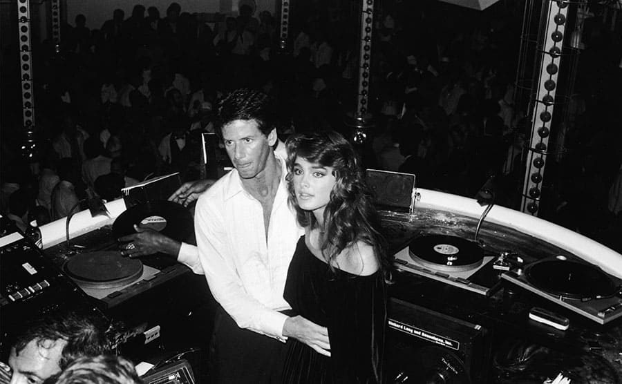 Brooke Shields and Calvin Klein standing in a DJ booth 