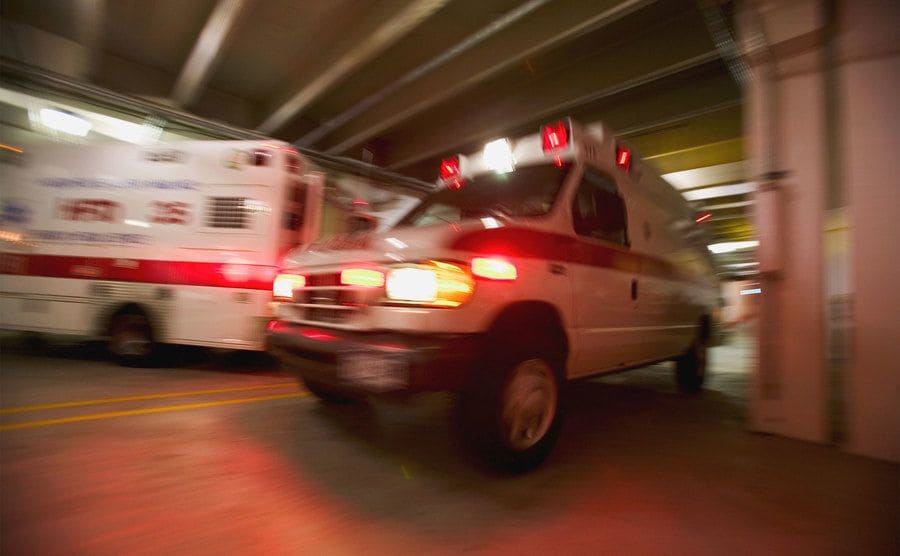 An ambulance rushing into a hospital parking lot. 