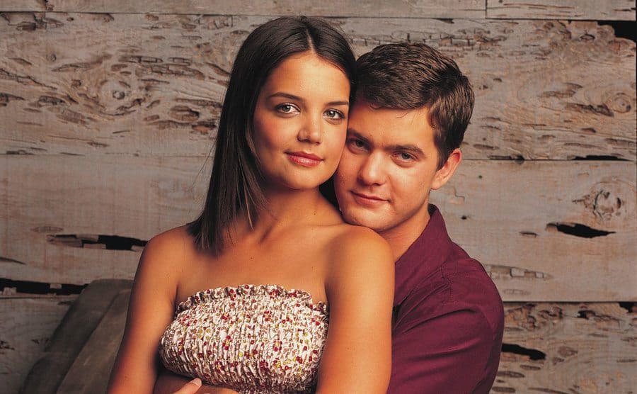 Katie Holmes sitting on Joshua Jackson’s lap for a photograph 
