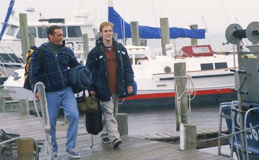 John Wesley Shipp and James Van Der Beek walking down the pier with camping gear 