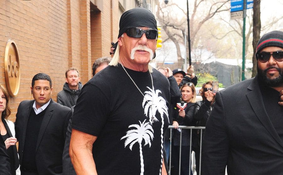 Hulk Hogan walking in the street in front of an ABC network building 