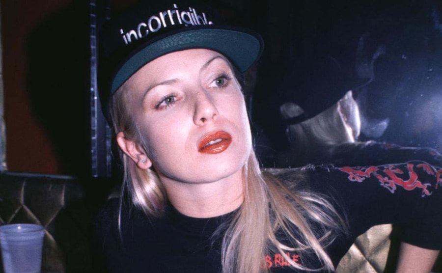 Traci Lords posing in a T-shirt and cap 