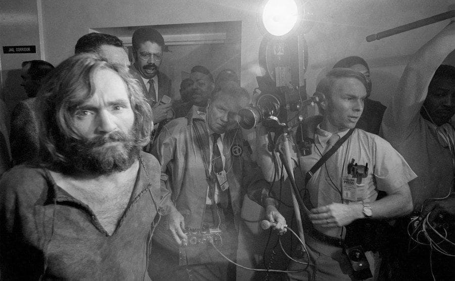 Cameramen film the scene as Charles Manson is brought into the Los Angeles city jail under suspicion of having masterminded the Tate-LaBianca murders of August 1969.